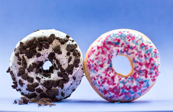 two vegan donuts against a blue background